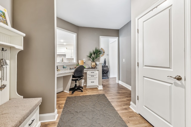 office area with built in desk and light hardwood / wood-style floors