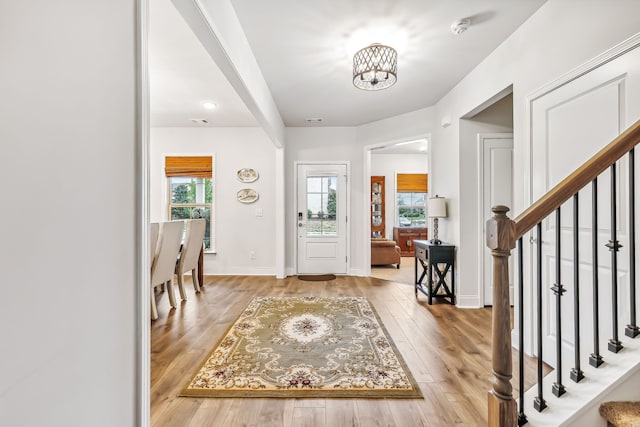 entryway with an inviting chandelier, light hardwood / wood-style flooring, and plenty of natural light