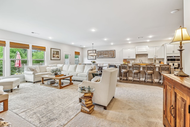 carpeted living room with sink