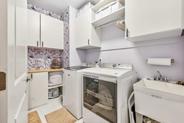 laundry room featuring cabinets, light hardwood / wood-style floors, separate washer and dryer, and sink