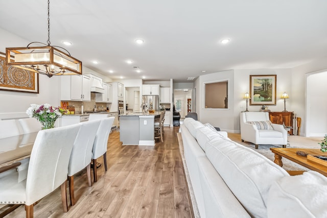 living room with a chandelier and light hardwood / wood-style floors