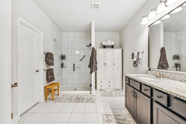 bathroom with tile patterned flooring, vanity, and an enclosed shower