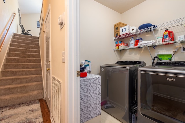 washroom with light wood-type flooring and washing machine and clothes dryer