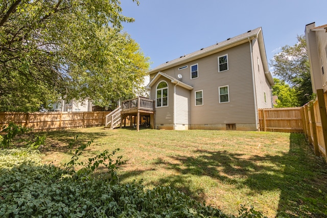 rear view of house with a yard and a deck