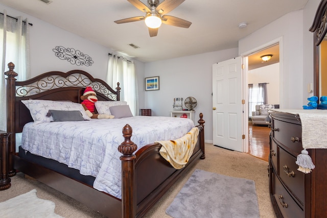 bedroom with ceiling fan and light carpet