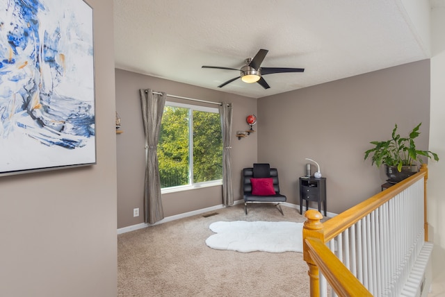 living area featuring a textured ceiling, ceiling fan, and carpet flooring