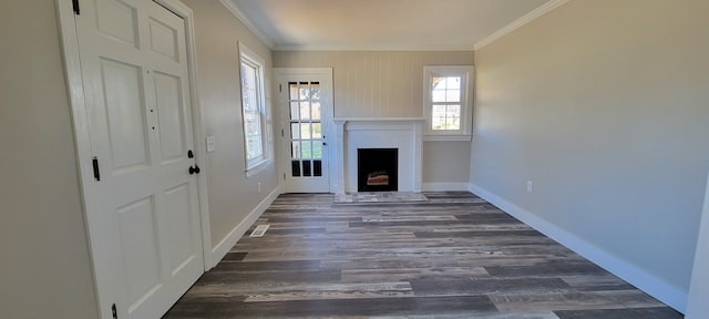 unfurnished living room featuring a fireplace, dark hardwood / wood-style floors, and crown molding