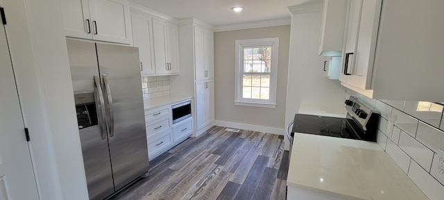 kitchen with dark wood-type flooring, stainless steel appliances, decorative backsplash, and white cabinets