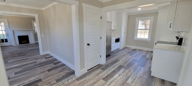 kitchen with crown molding, dark hardwood / wood-style floors, appliances with stainless steel finishes, and white cabinetry