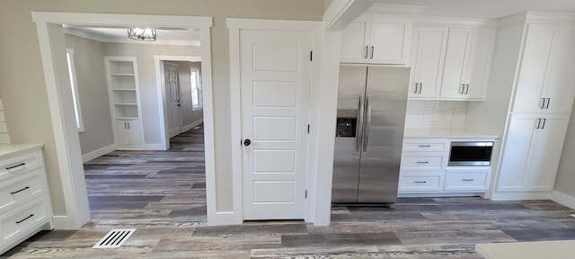 kitchen with stainless steel appliances, backsplash, hardwood / wood-style flooring, and white cabinets