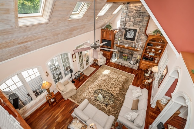 living room with a wealth of natural light, wood-type flooring, ceiling fan, and high vaulted ceiling