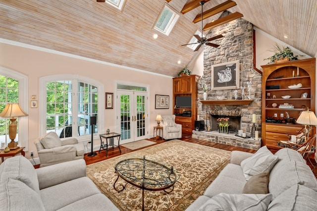 living room with a skylight, a fireplace, wooden ceiling, french doors, and ceiling fan