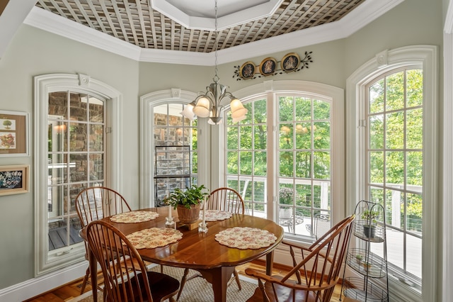 dining room with wood-type flooring, a chandelier, and ornamental molding