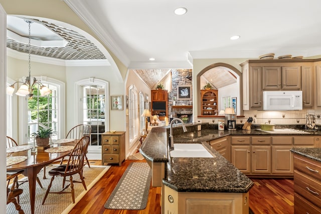 kitchen with a center island, a notable chandelier, sink, lofted ceiling, and dark hardwood / wood-style floors