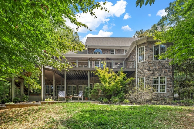 rear view of house featuring a lawn and a wooden deck