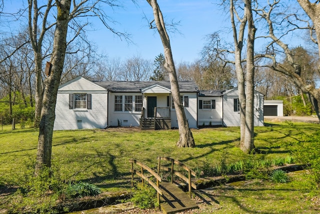 rear view of property with a garage, an outdoor structure, and a lawn