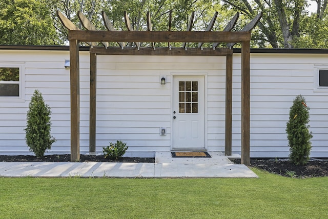 view of outbuilding with a pergola and a yard