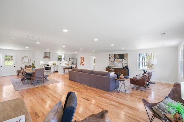 living room featuring light hardwood / wood-style floors, a healthy amount of sunlight, and sink