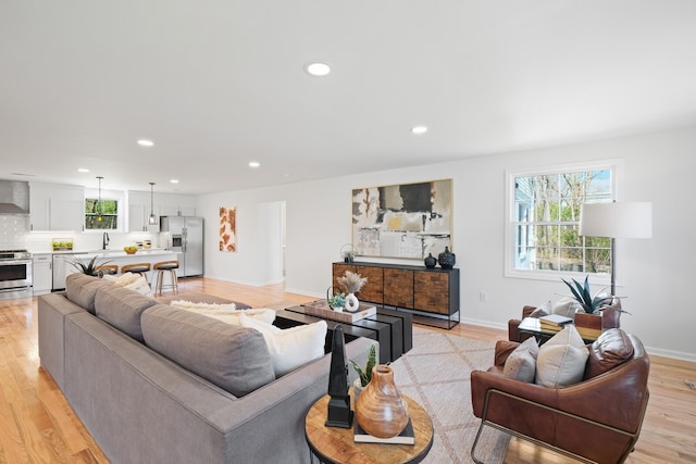 living room with light hardwood / wood-style flooring and sink