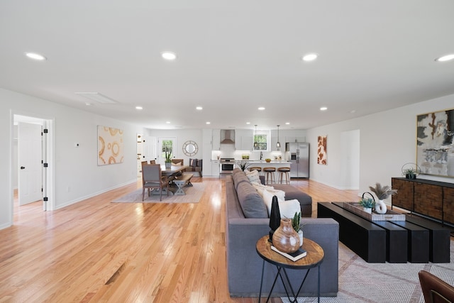 living room featuring sink and light hardwood / wood-style flooring