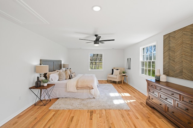 bedroom with multiple windows, ceiling fan, and light hardwood / wood-style flooring