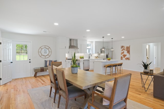 dining area with sink and light hardwood / wood-style flooring