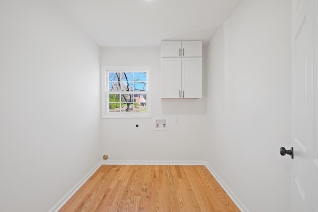 washroom with electric dryer hookup, washer hookup, cabinets, and light hardwood / wood-style floors