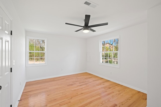 spare room with light wood-type flooring, a wealth of natural light, and ceiling fan