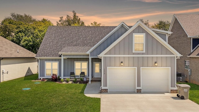 view of front facade featuring a garage, driveway, board and batten siding, and a front yard