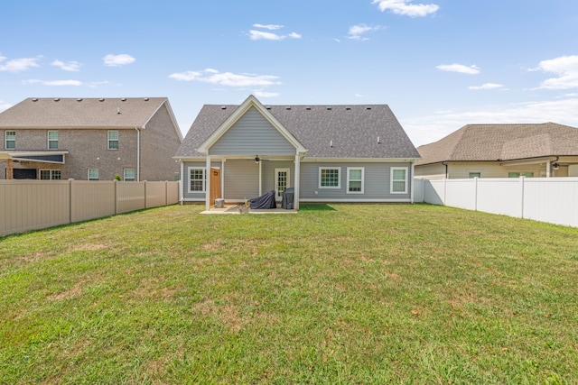 rear view of house with a fenced backyard, a yard, and a patio