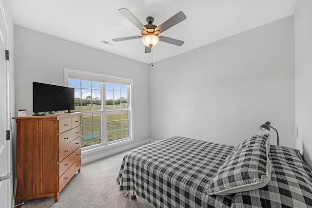 bedroom featuring ceiling fan, visible vents, and light colored carpet