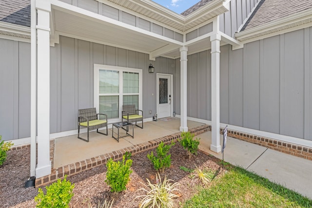 view of exterior entry featuring a porch, board and batten siding, and a shingled roof