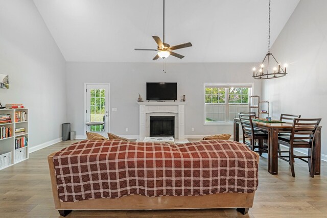 living area with high vaulted ceiling, light wood-style flooring, and a healthy amount of sunlight