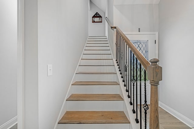 staircase with wood finished floors and baseboards