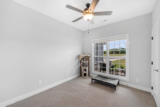 living area featuring ceiling fan, carpet, visible vents, and baseboards