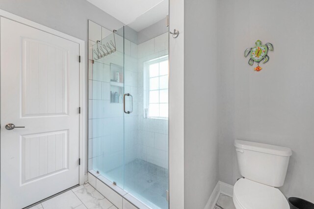 bathroom featuring marble finish floor, baseboards, a shower stall, and toilet