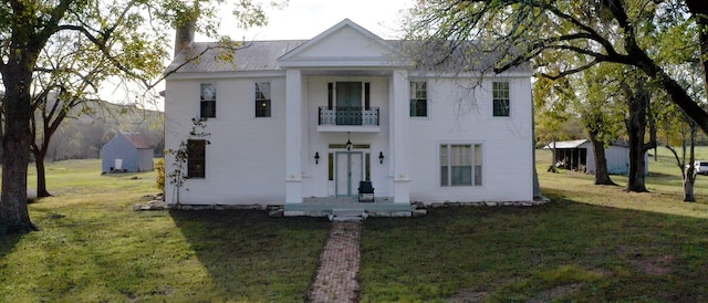 neoclassical / greek revival house with a balcony and a front lawn