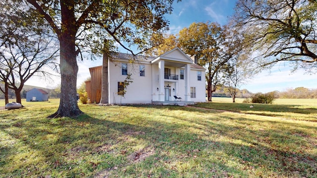 neoclassical / greek revival house with a balcony and a front lawn