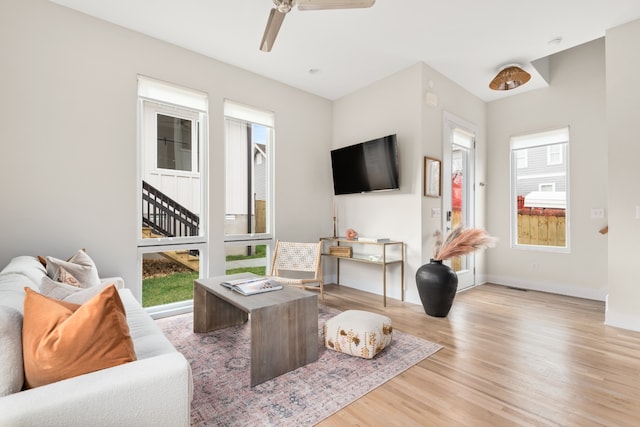 living room featuring ceiling fan, a wealth of natural light, and light hardwood / wood-style floors