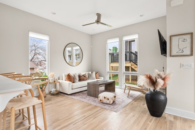 living room with light wood-type flooring and ceiling fan