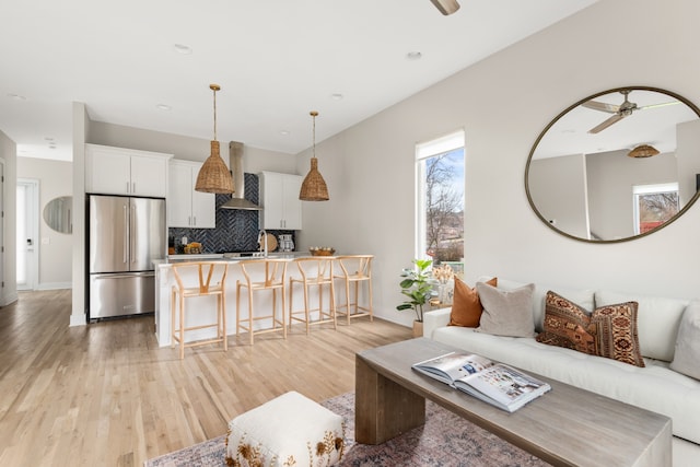 living room featuring ceiling fan and light wood-type flooring