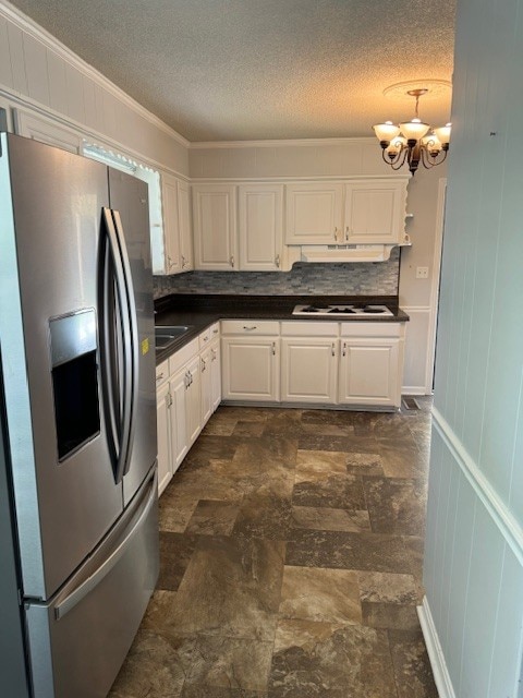 kitchen with a notable chandelier, white cabinetry, white gas stovetop, backsplash, and stainless steel fridge