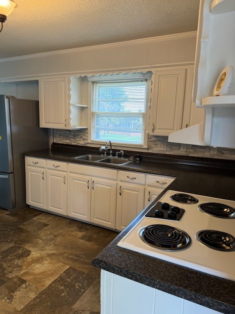 kitchen featuring white cabinetry, tasteful backsplash, a textured ceiling, ornamental molding, and sink