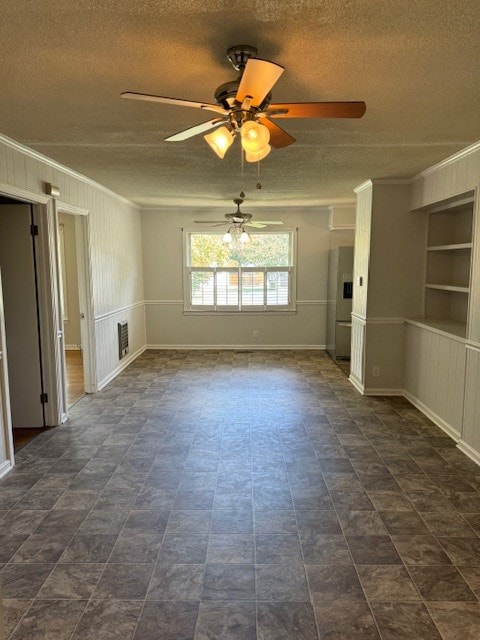 unfurnished living room with ceiling fan, a textured ceiling, built in features, and crown molding