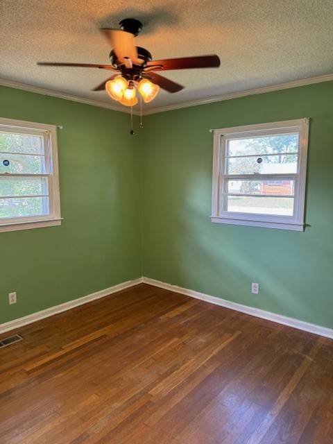 spare room featuring ceiling fan, a textured ceiling, plenty of natural light, and dark wood-type flooring