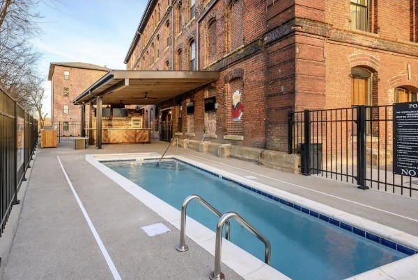 view of swimming pool featuring exterior kitchen and a patio