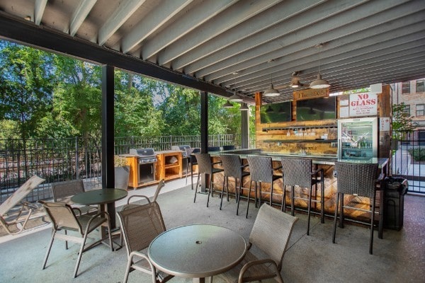 view of patio featuring a bar, ceiling fan, and area for grilling