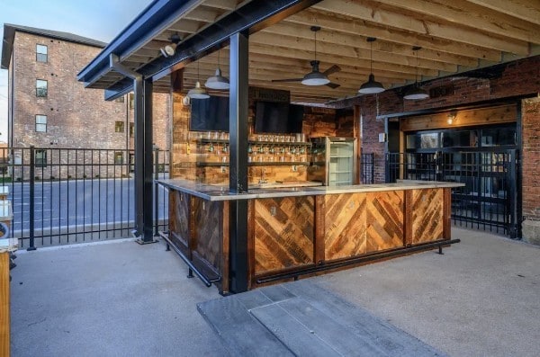 bar featuring concrete flooring and brick wall