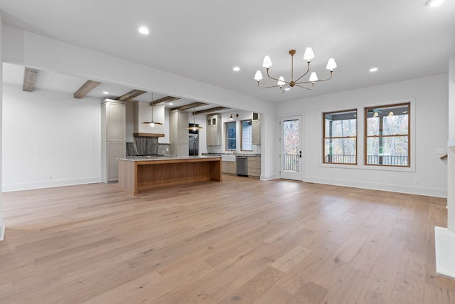 kitchen featuring hanging light fixtures, stainless steel dishwasher, a kitchen island, light hardwood / wood-style floors, and beam ceiling