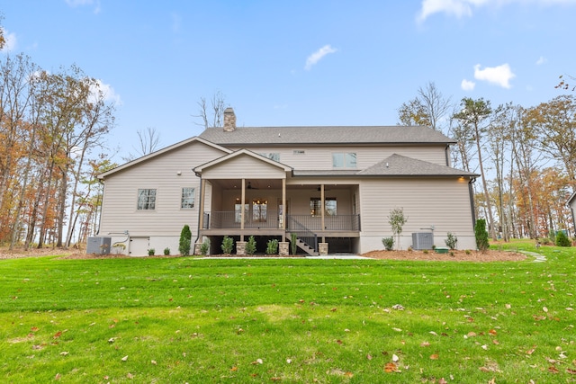 rear view of property with a sunroom, ceiling fan, a yard, and central AC unit